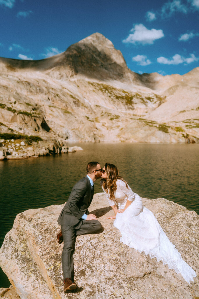 bride and groom kissing on rock in Indian peaks wilderness