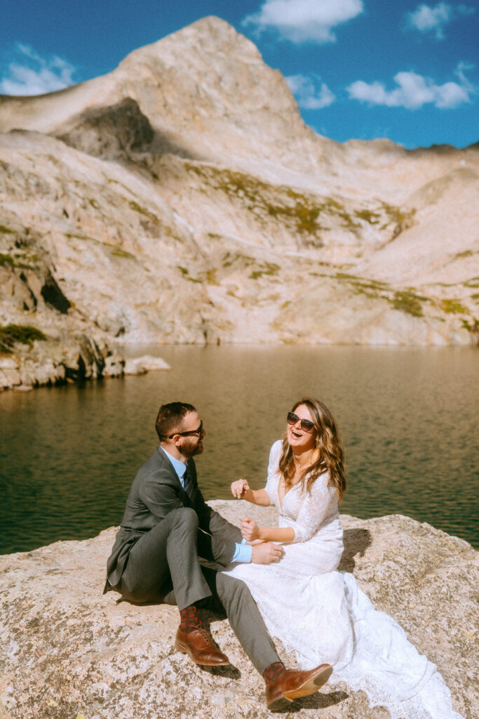 bride and groom laughing on rock in Indian peaks wilderness
